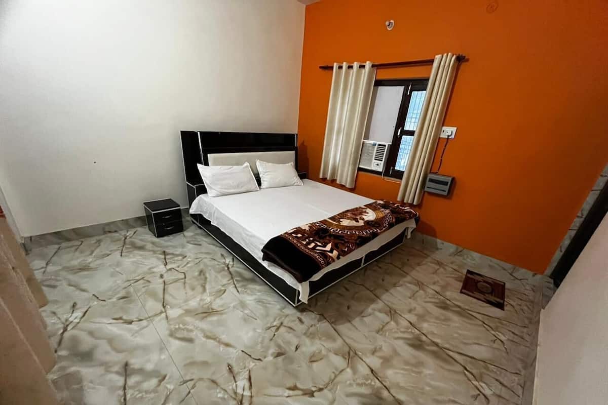 Quarto com cama, mesa de cabeceira e ar condicionado.