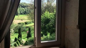 A room with a large window overlooking a garden. - La Vallée Verte (Grandchamp)