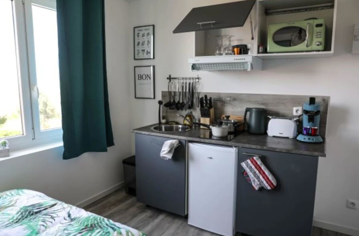 A compact kitchenette with a microwave, toaster, and sink.