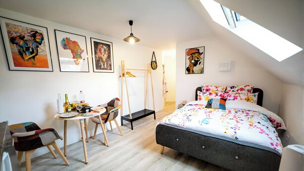 A bedroom with a bed, a desk, a chair, and artwork on the walls. - Residence Kelys (Boulogne-sur-Mer)