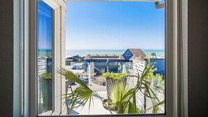 A balcony with a view of the sea and buildings.