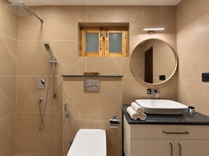 Un bagno con doccia, WC, lavandino e specchio.