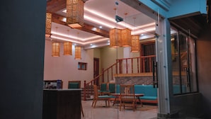 A modern interior with a staircase, wooden furniture, and hanging lanterns. - The Rangjung Hotel (Leh)