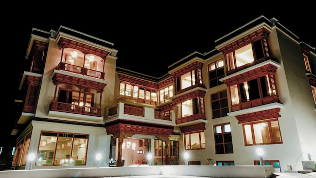 A multi-story building with traditional architectural features, including wooden balconies and large windows. - The Rangjung Hotel (Leh)