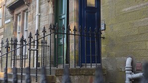 A stone building with a green door and a blue door. - Skye Sands | Kinburn (No 2a) (St Andrews)