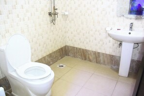 Une salle de bain avec des toilettes, une douche et un lavabo.