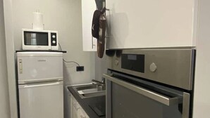 A compact kitchen with a microwave, refrigerator, and oven.