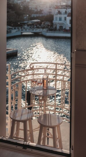 Enjoy a serene view of the water from this balcony with a dining area and ornate railing.
