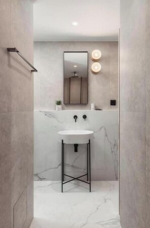 Bathroom features a sink, mirror, and wall-mounted lights.