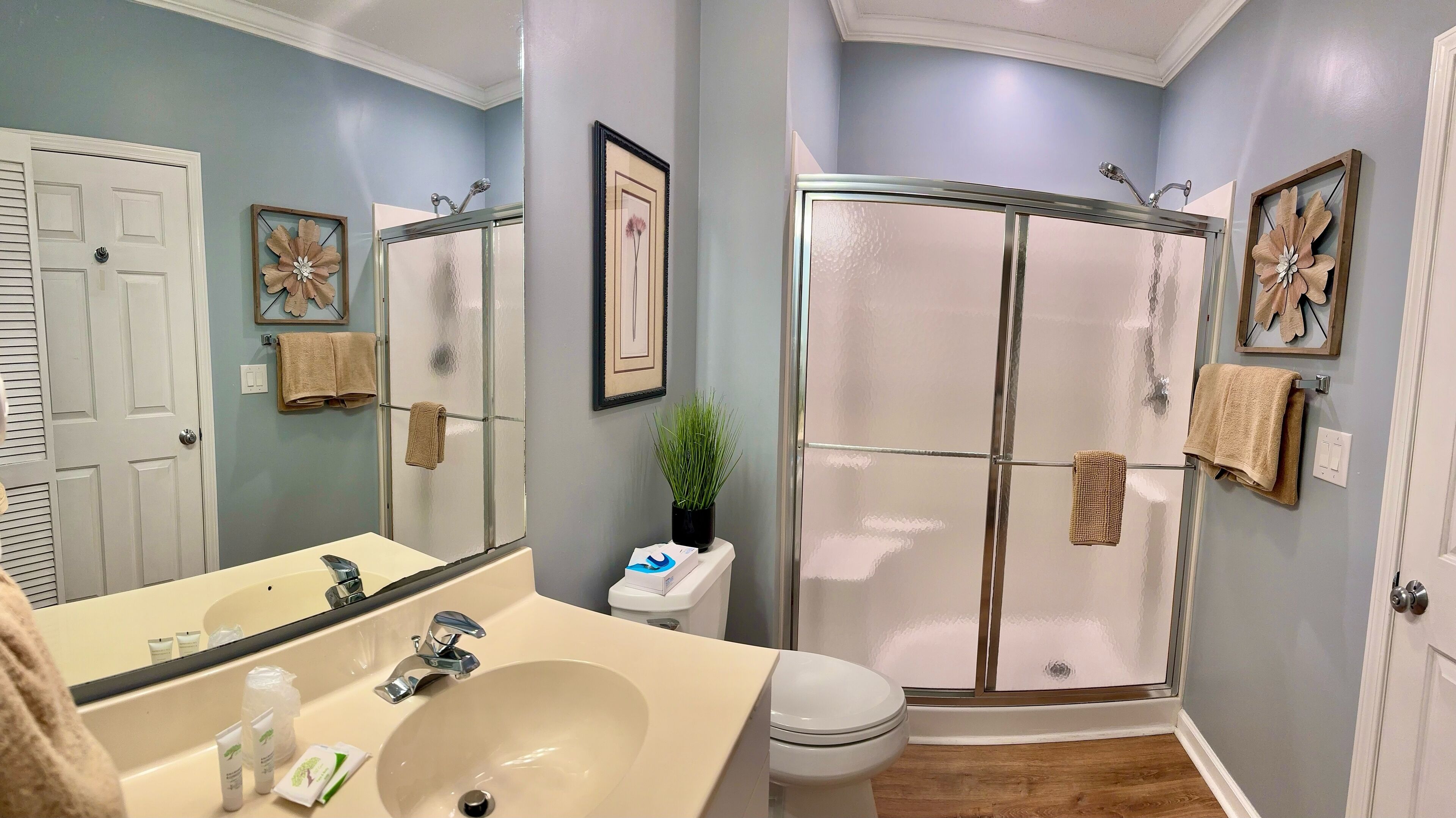 A bathroom with a sink, toilet, and glass shower enclosure.