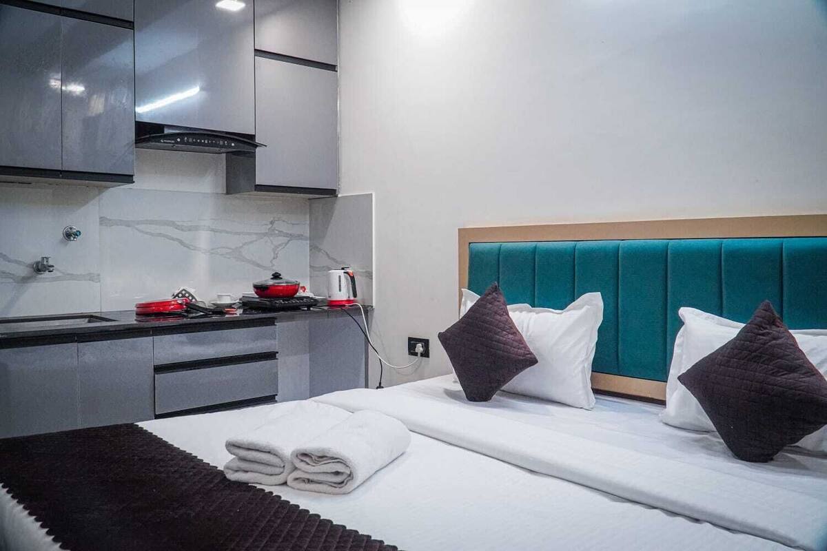 Una habitación de hotel con cama, kitchenette y baño.