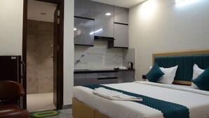 Una habitación de hotel moderna con cama, baño y kitchenette.