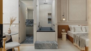 Une chambre d’hôtel moderne avec un lavabo intégré, un lit avec une literie blanche, une table de chevet et une petite table ronde agrémentée d’un vase.