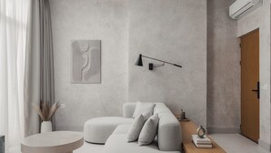Un salon moderne avec un canapé d’angle, une table basse ronde et un style de décoration minimaliste.