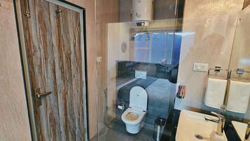 Un baño moderno con ducha acristalada, inodoro y lavabo.