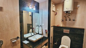 Une salle de bain avec deux lavabos, un miroir, des toilettes et une douche.