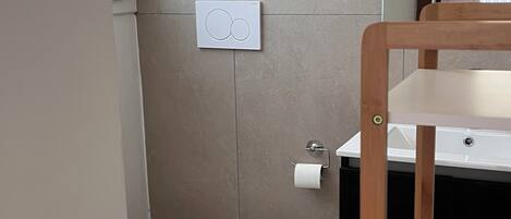A bathroom with a toilet, a sink, and a mirror.