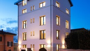 A multi-story hotel with a flat roof, evenly spaced windows, and a well-lit entrance.