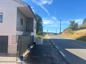 Um edifício com fachada revestida de azulejos, calçada pavimentada e rua com placa de limite de velocidade.