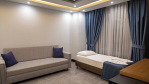 Un dormitorio moderno con un sofá, una cama individual y una mesa de madera.