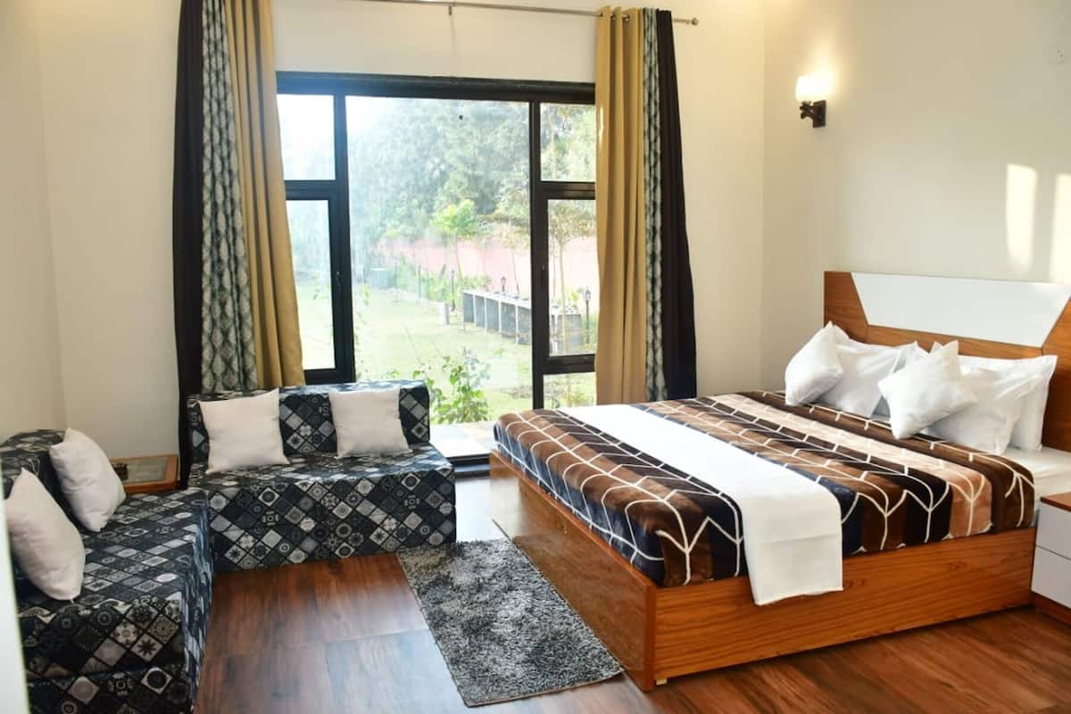 Une chambre à coucher avec un grand lit, un canapé et une fenêtre avec des rideaux.