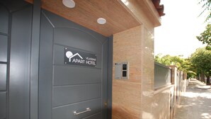 Una puerta gris con un letrero que dice "Vilassar Apart Hotel" y una cerradura electrónica.