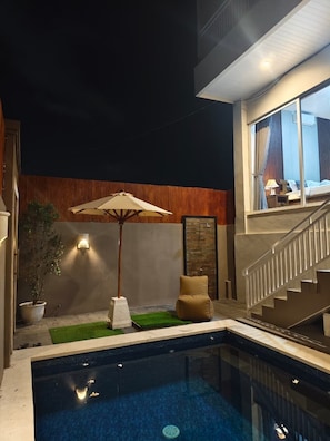 A modern indoor pool area with a staircase, a potted plant, and a seating area. - Sarining 2BR Villa with Pool (Ungasan)