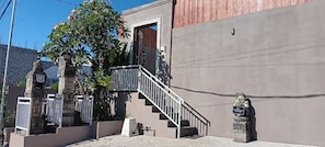 A building with a concrete facade, a metal staircase, and a small statue. - Sarining 2BR Villa with Pool (Ungasan)