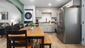 Une cuisine compacte comprenant un coin repas, un lave-linge et un réfrigérateur.