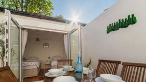 Un coin repas avec une table dressée pour quatre personnes, une bouteille d’eau bleue et un verre d’eau.