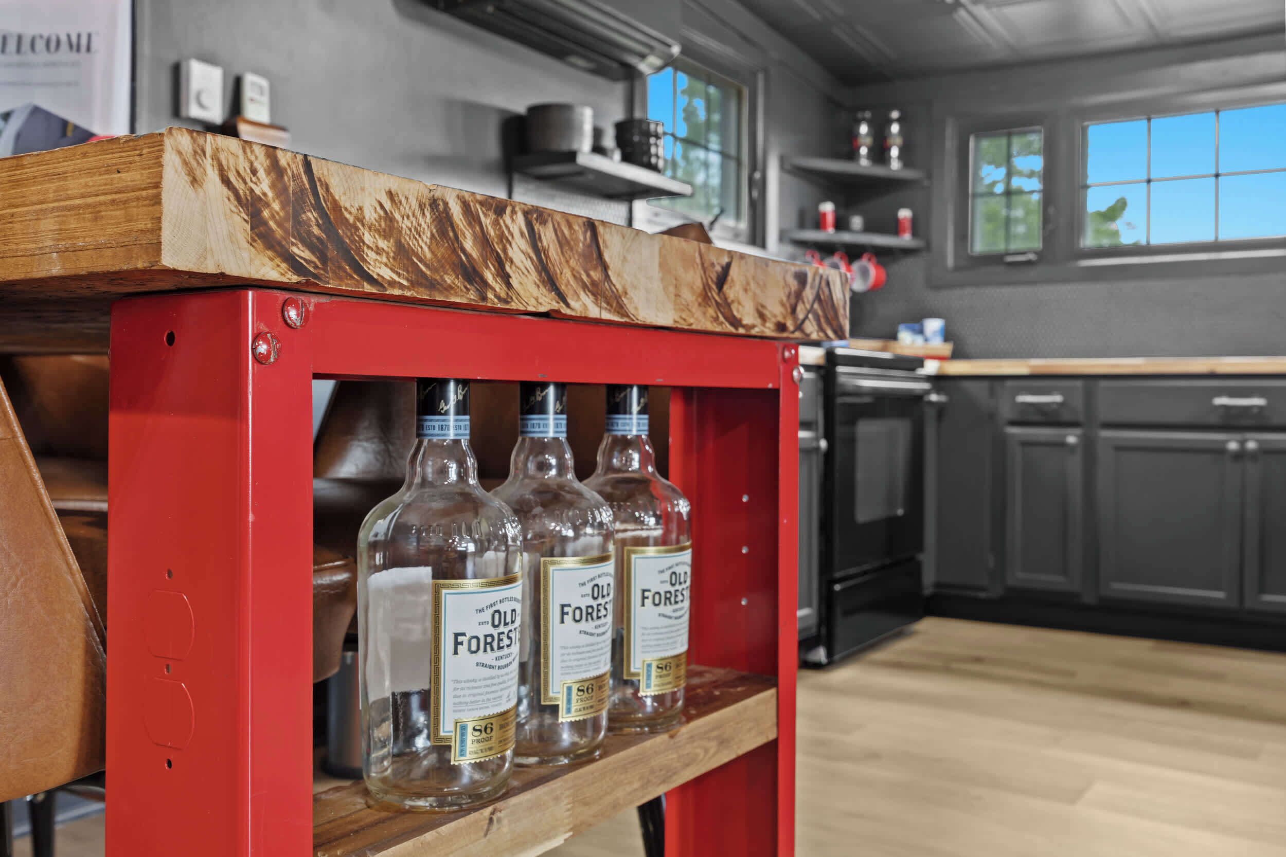 Una cucina con uno scaffale in legno che contiene tre bottiglie etichettate 'Old Forest'.