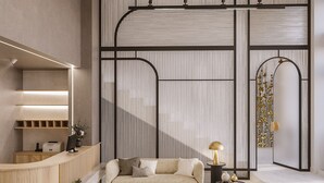 A modern interior with a sofa, a desk, and a decorative wall panel. - 1910 Legacy Hotel (Volos)