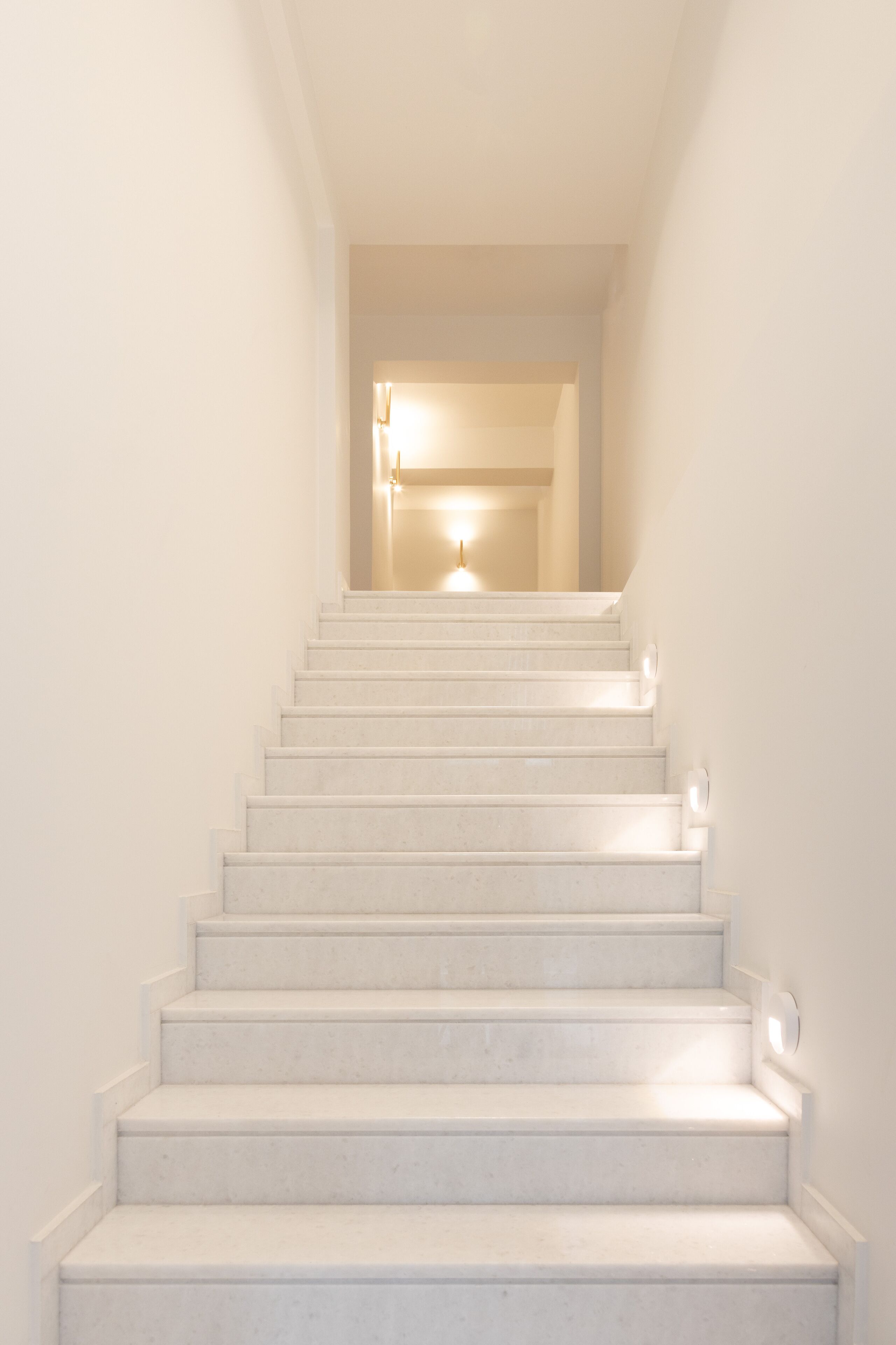A staircase leading to a landing with a light fixture at the top.
