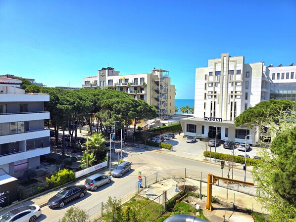Un edificio moderno con varios pisos, un área de estacionamiento y vista al mar.