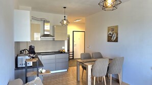 Een moderne keuken met een eethoek, inclusief een tafel en stoelen, en een bank.