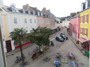 A street with buildings, a bench, and a bicycle.