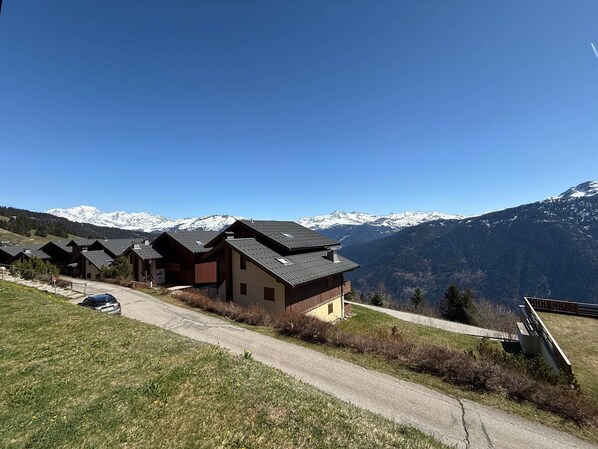 A row of chalet-style buildings with a mountain backdrop.