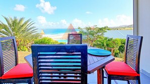 A dining area with a view of the beach and ocean. - Spacious sea-facing studio with air conditioning (Saint-Martin)