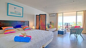 A hotel room with two beds, a balcony with outdoor seating, and a view of the sea. - Spacious sea-facing studio with air conditioning (Saint-Martin)