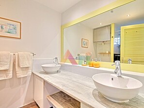 A bathroom with two sinks, a mirror, and towels. - Spacious sea-facing studio with air conditioning (Saint-Martin)