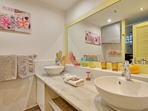 A bathroom with a large mirror, two sinks, and a towel rack. - Spacious sea-facing studio with air conditioning (Saint-Martin)