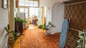 A hallway with a patterned carpet, potted plants, a brown headboard, and a dining area in the background. - "bojana", Charming Accomodation in Razlog, Bulgaria (Razlog)