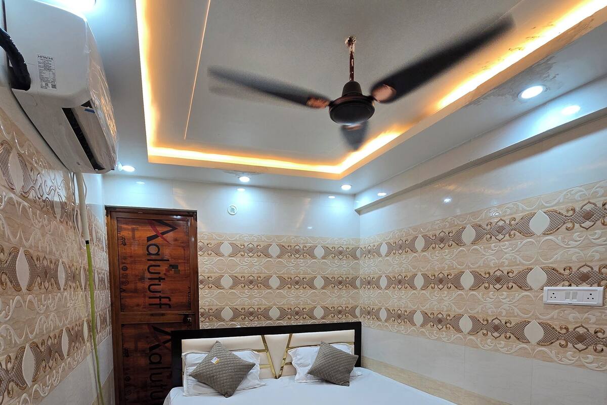 Ein modernes Schlafzimmer mit einem Bett, Wandmustern und einem Deckenventilator.