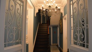 A staircase with a chandelier and decorative iron railings. - Villa in Coo Near Waterfalls With Pool (Stavelot)
