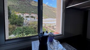 Une cuisine avec une fenêtre donnant sur une colline.
