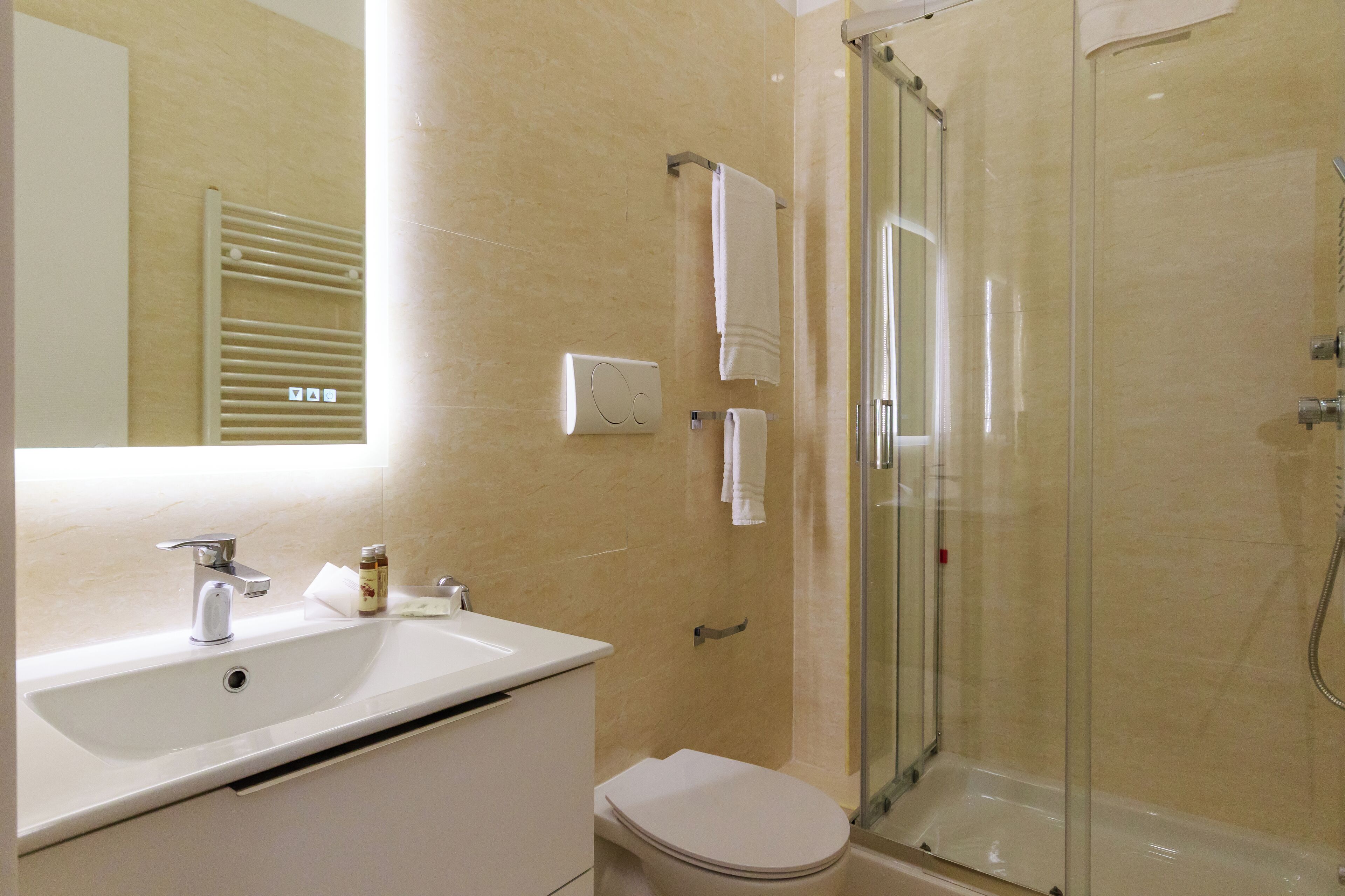 Une salle de bain moderne avec un lavabo, des toilettes et une douche à parois de verre.