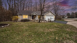 A single-story house with a front porch, a garage, and a well-maintained lawn.