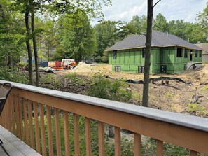 A green house under construction with a wooden deck in the foreground. - Summerwood Cottage (South Haven)