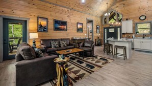 A spacious living room with a wooden ceiling, a sofa, a coffee table, and a rug.