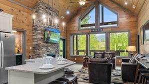 A spacious kitchen with a large island, stone accents, and a dining area with leather furniture.